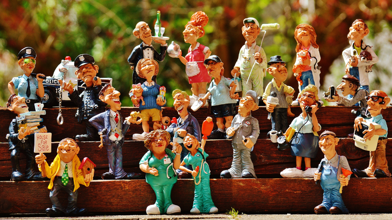 Photo of a group of people made from modelling clay dressed in various different work outfits like hard hats and scubs.