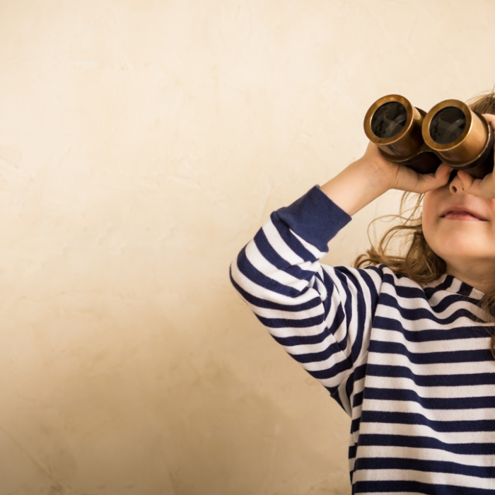 Photo of young girl looking through binoculars
