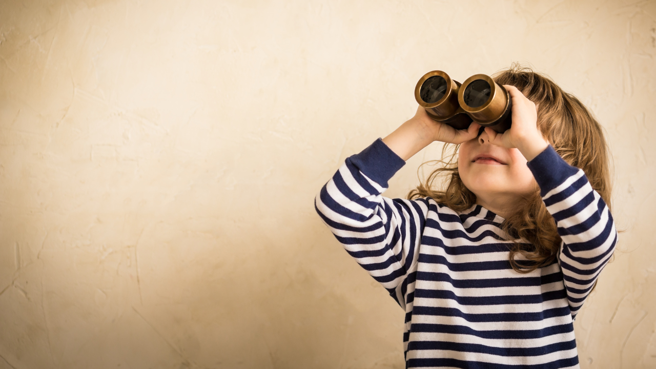 Photo of young girl looking through binoculars