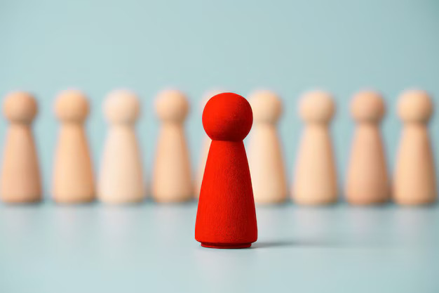 Red wooden figure standing in front of others.